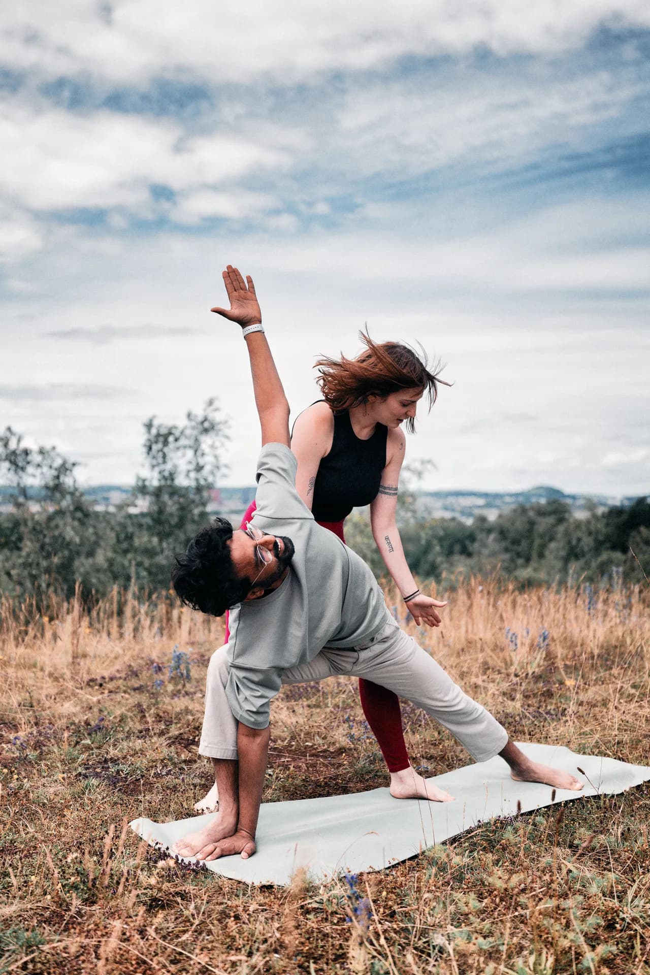 Yoga teacher guiding a student outdoors